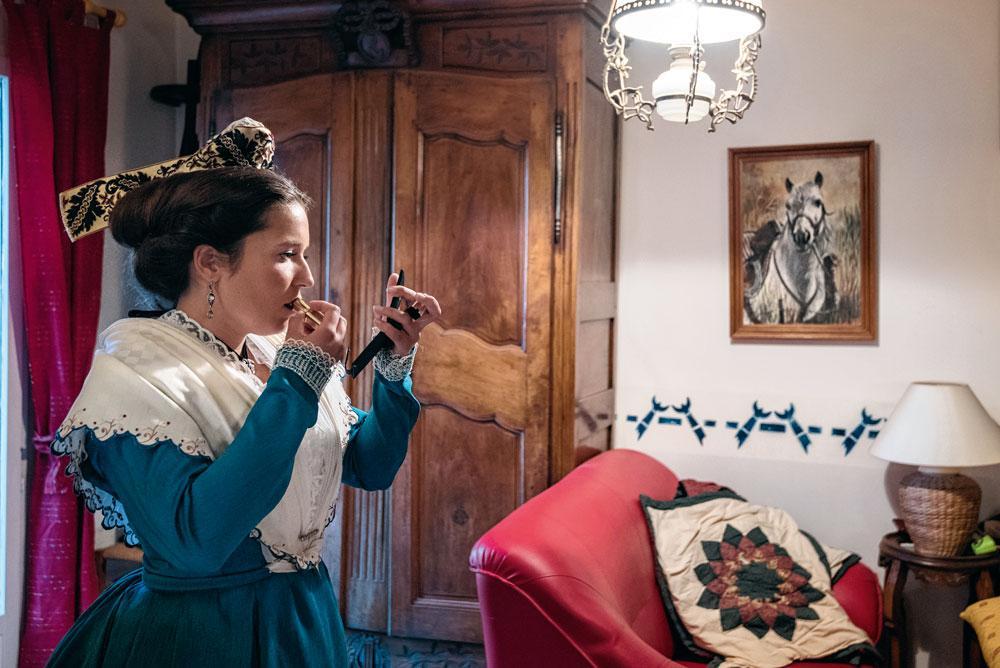 Après deux heures d'habillage et de coiffure, la manadière Aude Raynaud termine sa préparation pour le défilé du 1er mai. Les femmes en costume d'Arlésienne sont de toutes les fêtes.