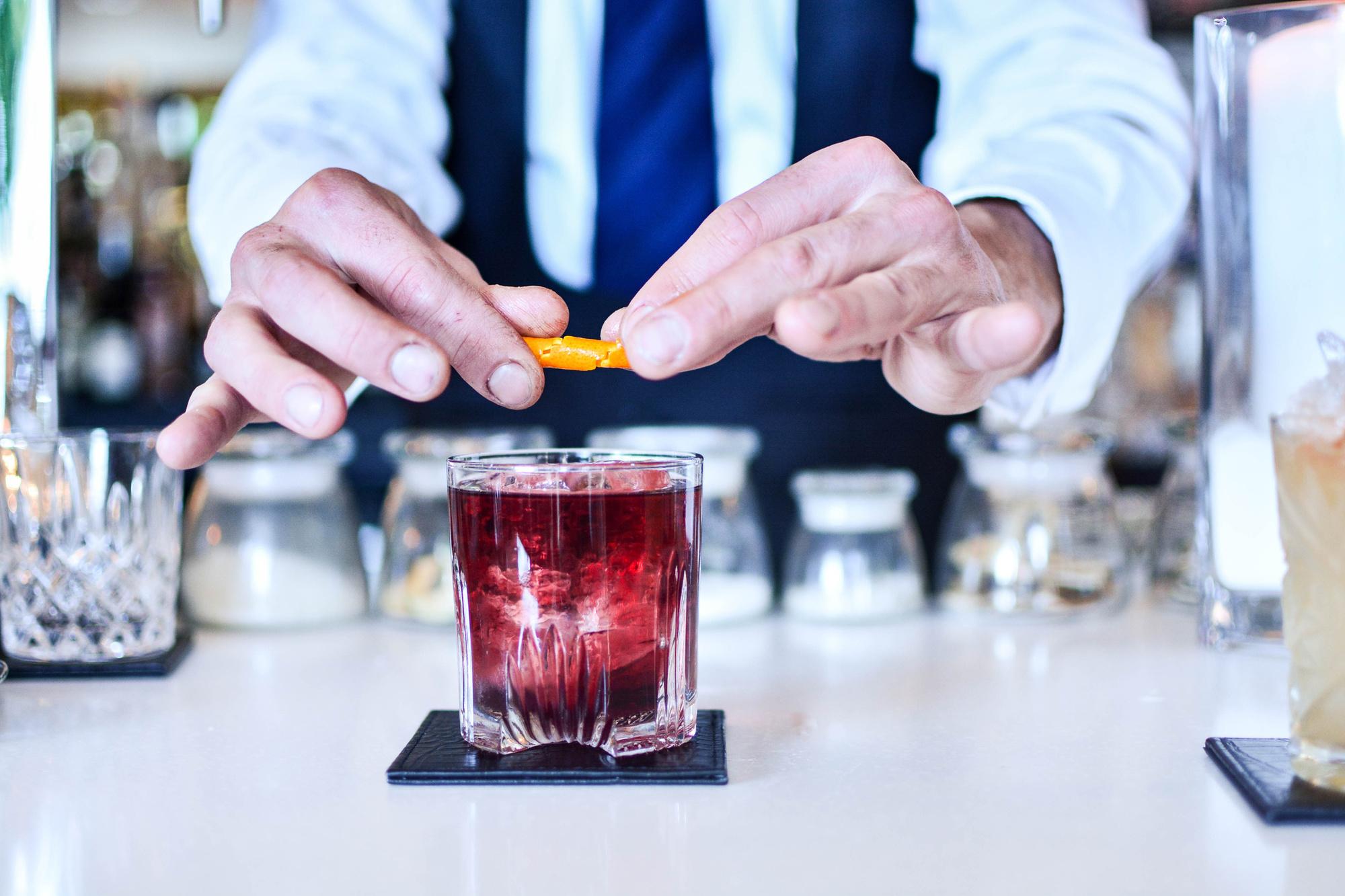 Barman serveert Negroni cocktail