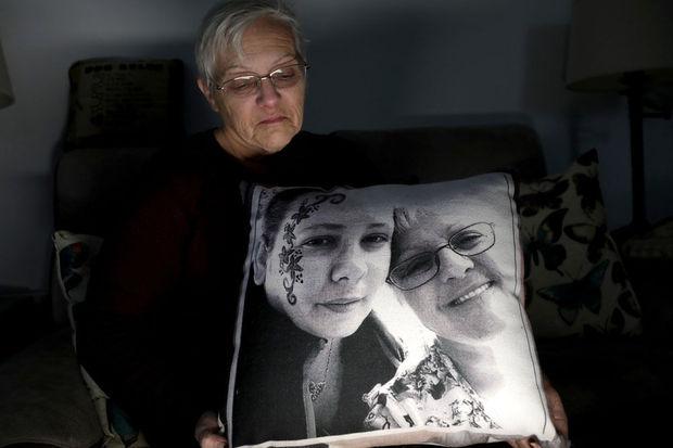 Deborah Fuller pose pour une photo pour The Associated Press avec un oreiller montrant une photo de sa défunte fille, Sarah Fuller, à gauche, qui est morte d'une overdose de médicaments sur ordonnance.