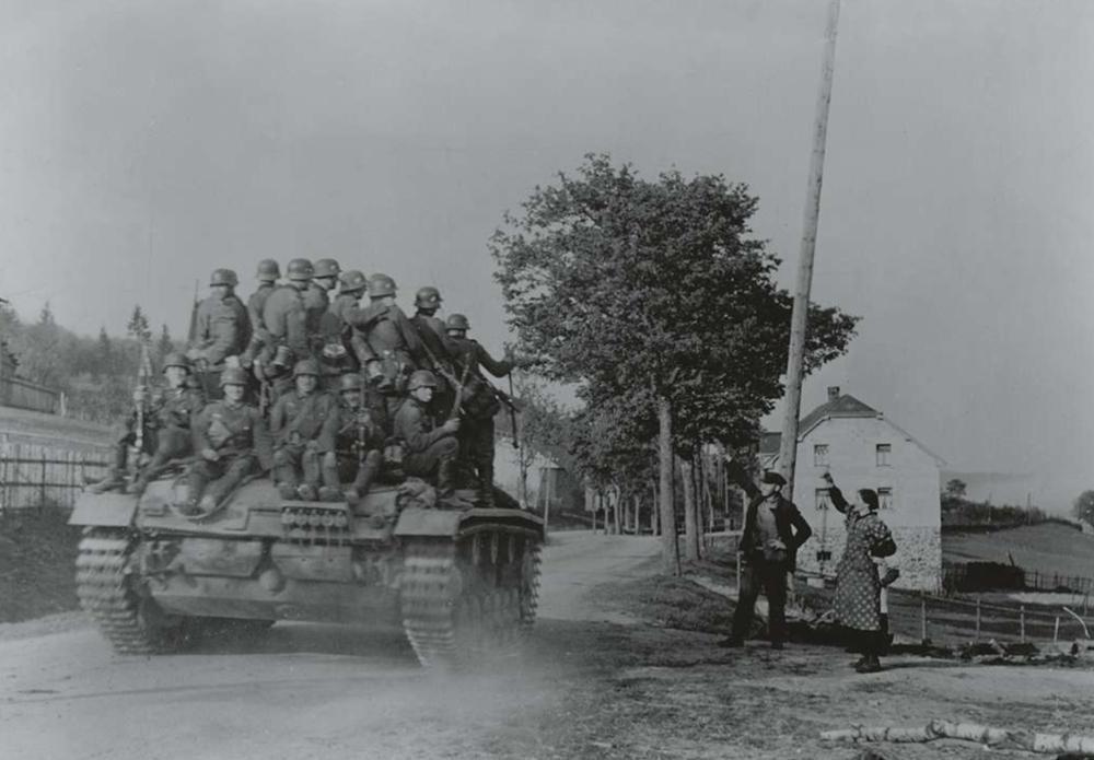 Etonnamment, le blindé transportant de nombreux soldats allemands ne semble pas effrayer les citoyens belges.