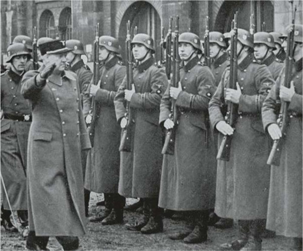Le diplomate norvégien et leader fasciste Vidkun Quisling saluant les troupes nazies lors d'une visite en Allemagne en 1935.