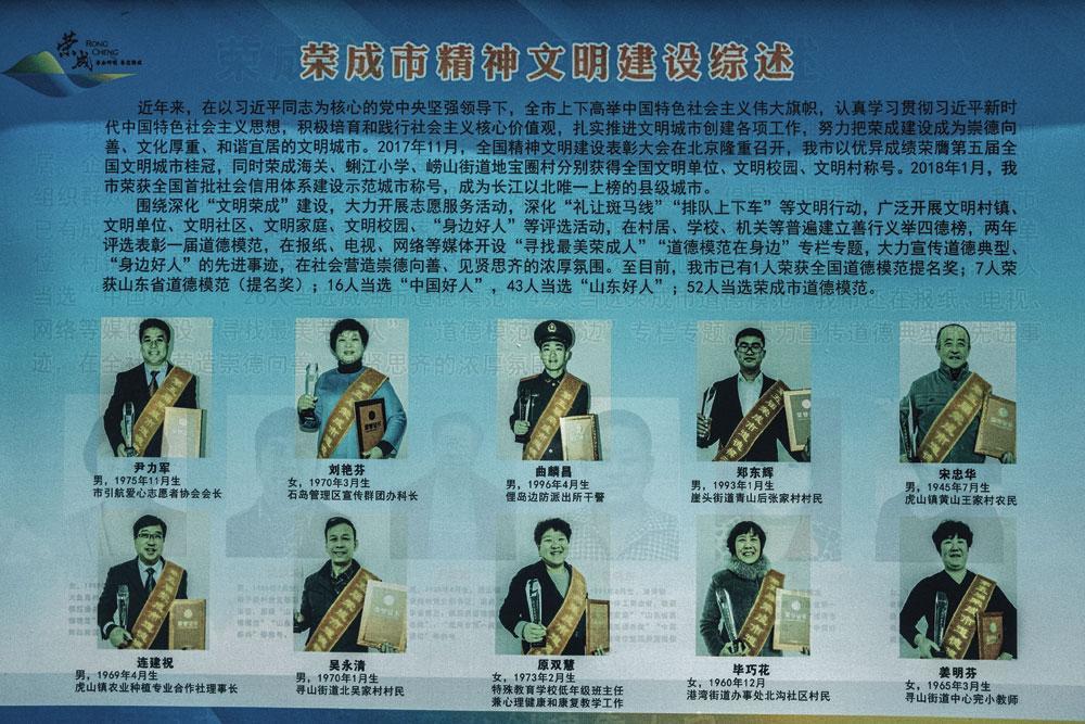 A  Rongcheng, dans la province du Shandong, des portraits de citoyens modèles sont affichés dans la rue.
