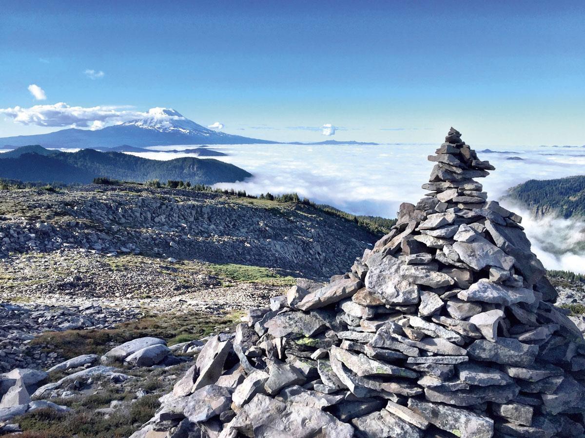 Depuis les sentiers du Goat Rocks Wilderness, le cratère enneigé du mont Adams semble cracher une coulée de nuages.