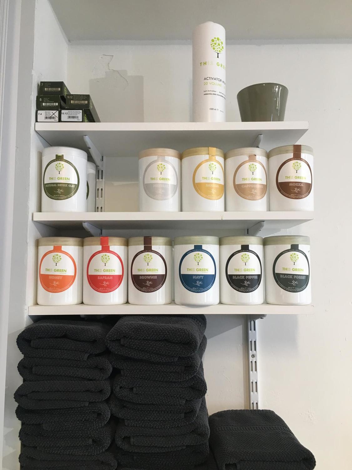 Les différentes poudres colorantes disposées sur une étagère au sein du salon de coiffure végétale
