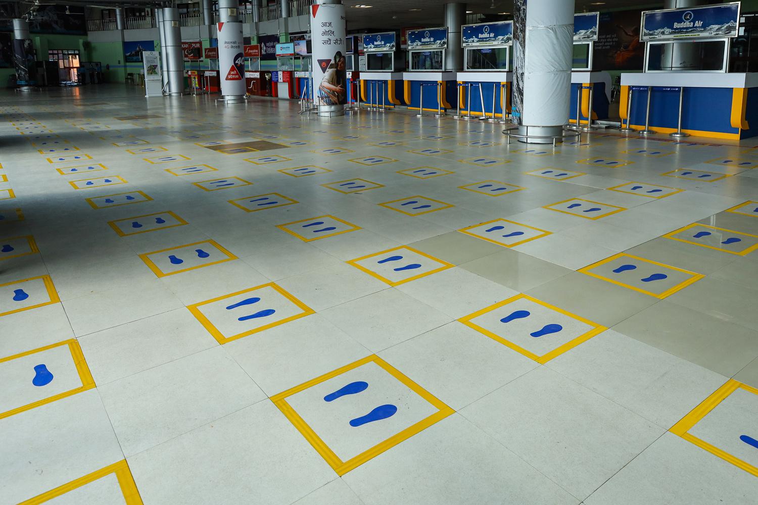 La distanciation sociale rendue visible à l'aéroport de Kathmandou au Népal