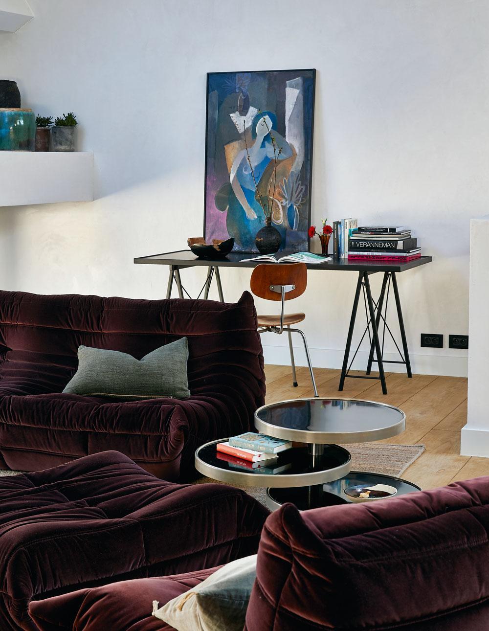 Le coin salon du premier étage avec ses fauteuils Togo (Ligne Roset), l'iconique bureau de Jules Wabbes et une chaise vintage signée Egon Eiermann.