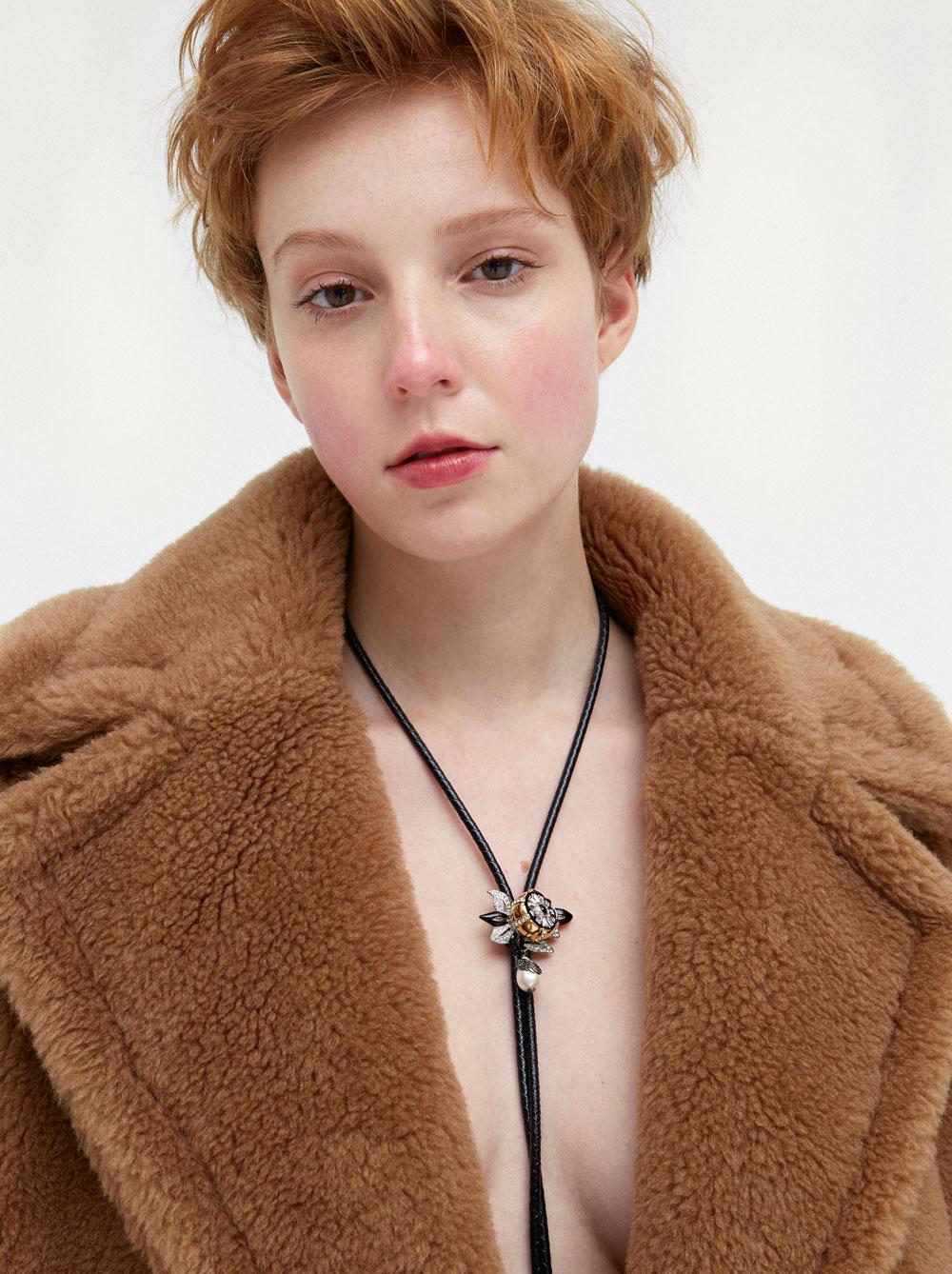 Manteau ample en laine de chameau effet fourrure, MaxMara. Collier en cuir noir tressé, Louis Vuitton.