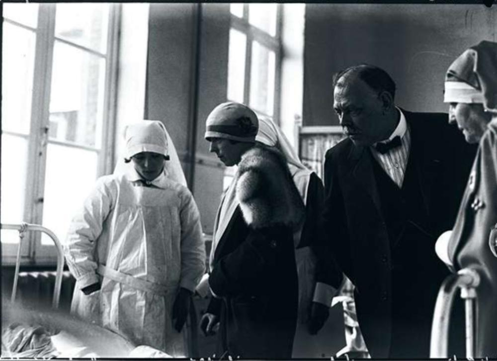 1927, Estinnes-au-Val. Élisabeth visite des mineurs blessés après une explosion ayant fait trente-deux morts.