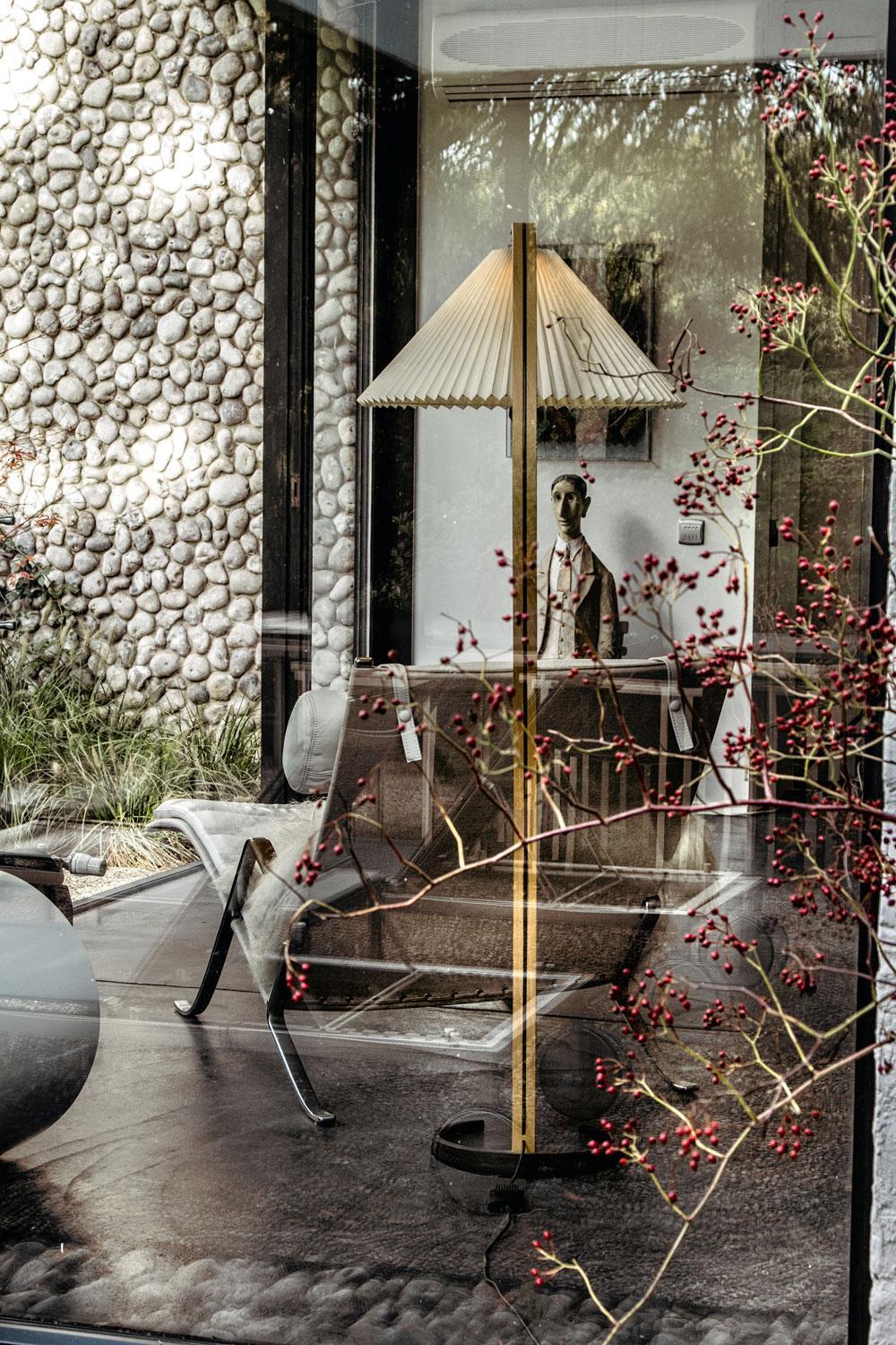 Le mur en galets du jardin a donné du fil à retordre à son concepteur. A l'avant-plan, une lampe scandinave vintage chinée.