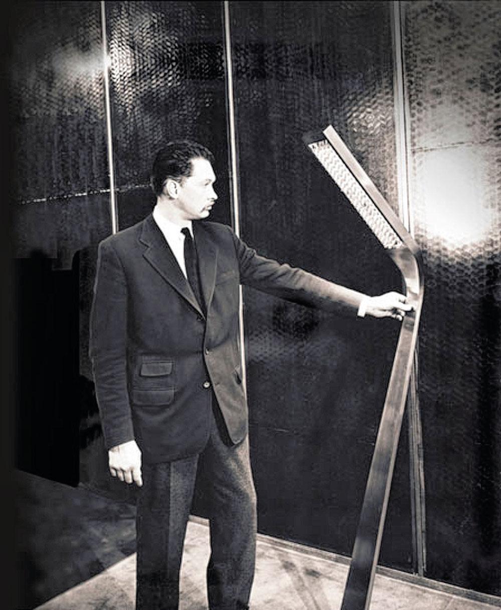 Jules Wabbes (1919-1974) lors de la présentation d'un prototype de luminiare en métal, l'un de ses matériaux de prédilection.