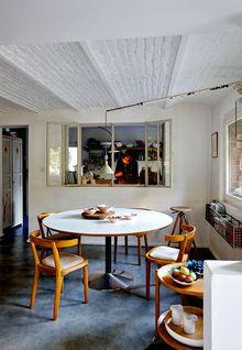 Le châssis métallique, la lampe Triplex et les voussettes peintes en blanc donnent un caractère industriel à la salle à manger. 