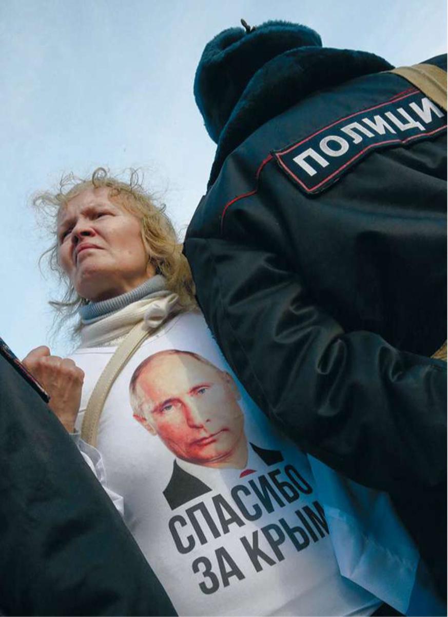 Moscou, le 18 mars 2015. Lors du premier anniversaire de l'annexion de la Crimée, une femme affirme son soutien à Poutine. Elle porte un tee-shirt avec l'inscription 