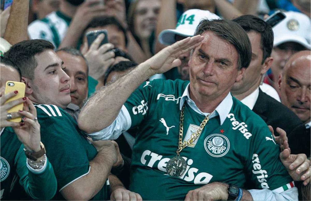 Le président brésilien Jair Bolsonaro salue des fans lors d'un match de footbal.