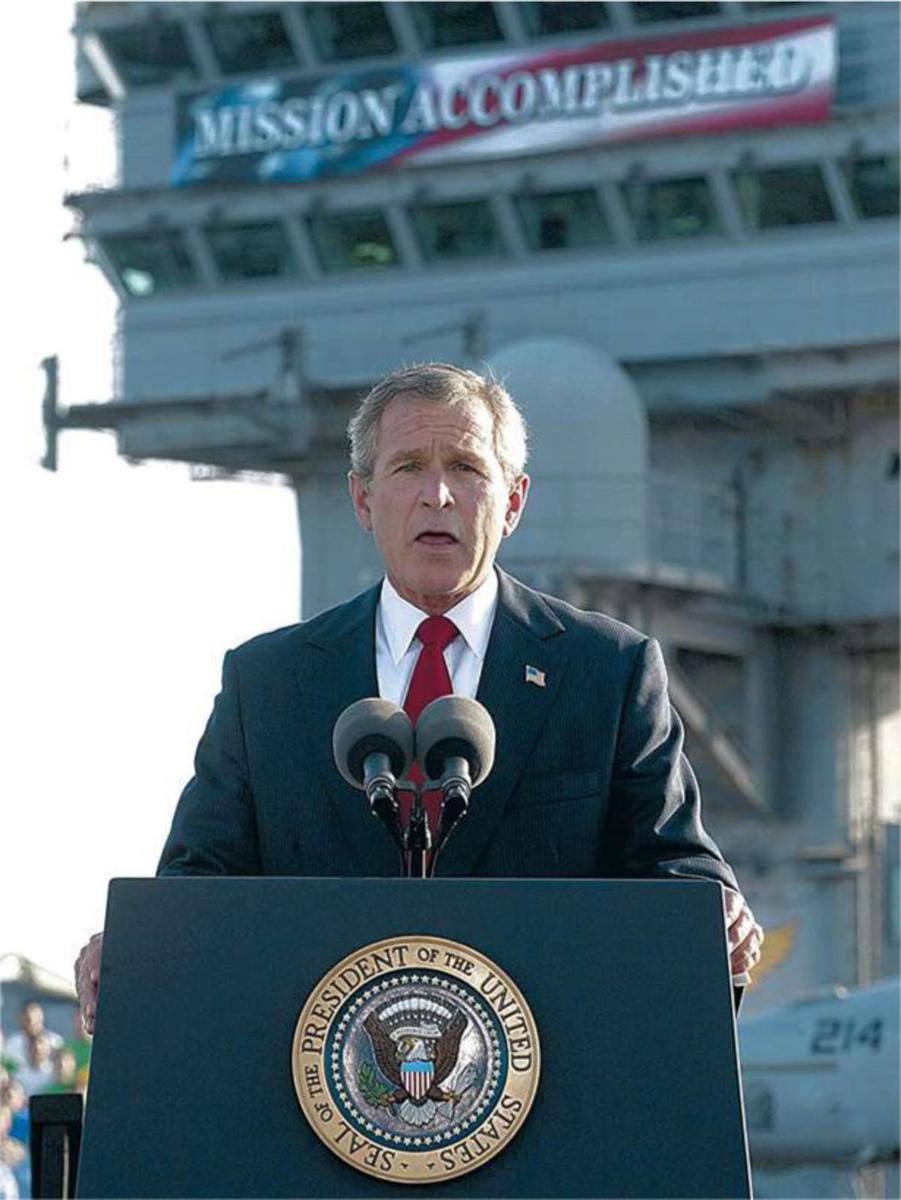 Le président George W. Bush, le 1er mai 2003. Derrière lui une bannière avec les mots Mission Accomplished. La catastrophe irakienne ne fait encore que commencer.