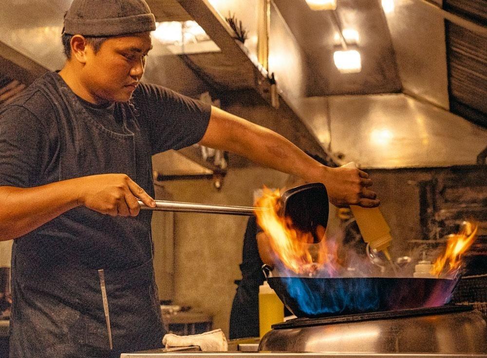 Le wok constitue un des outils clés de la cuisine locale, influencée par la Chine.