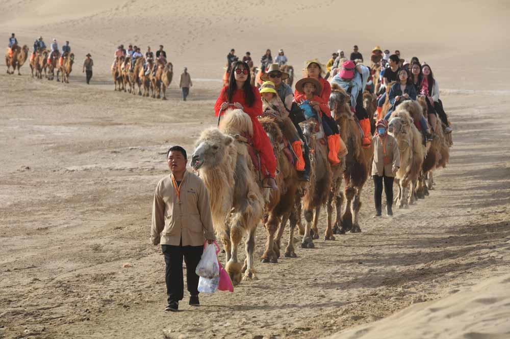 Route de la soie: ces touristes à l'assaut des dunes Dunhuang (en images)