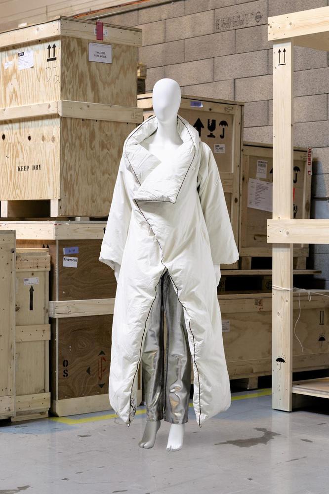 Martin Margiela, Automne-Hiver 1999-2000Manteau-duvet long blanc avec manches amovibles bordé de ganse marronEstimation : 8.000-10.000?Jean rehaussé de peinture vieil argentEstimation : 1.000-1.200?