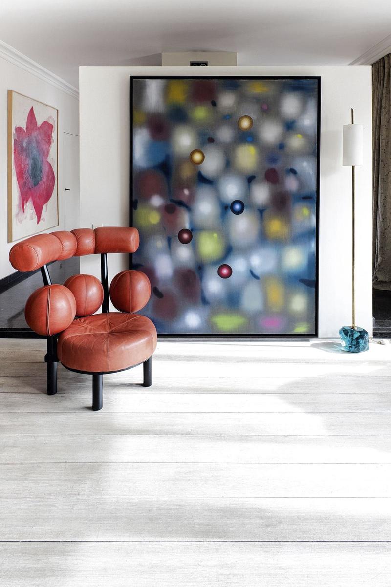 Un fauteuil norvégien vintage en cuir rouge devant une oeuvre de l'Américain Ross Bleckner.