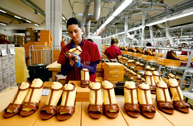 Au siège de Tod's, en Italie, une employée finalise une ligne de sandales.