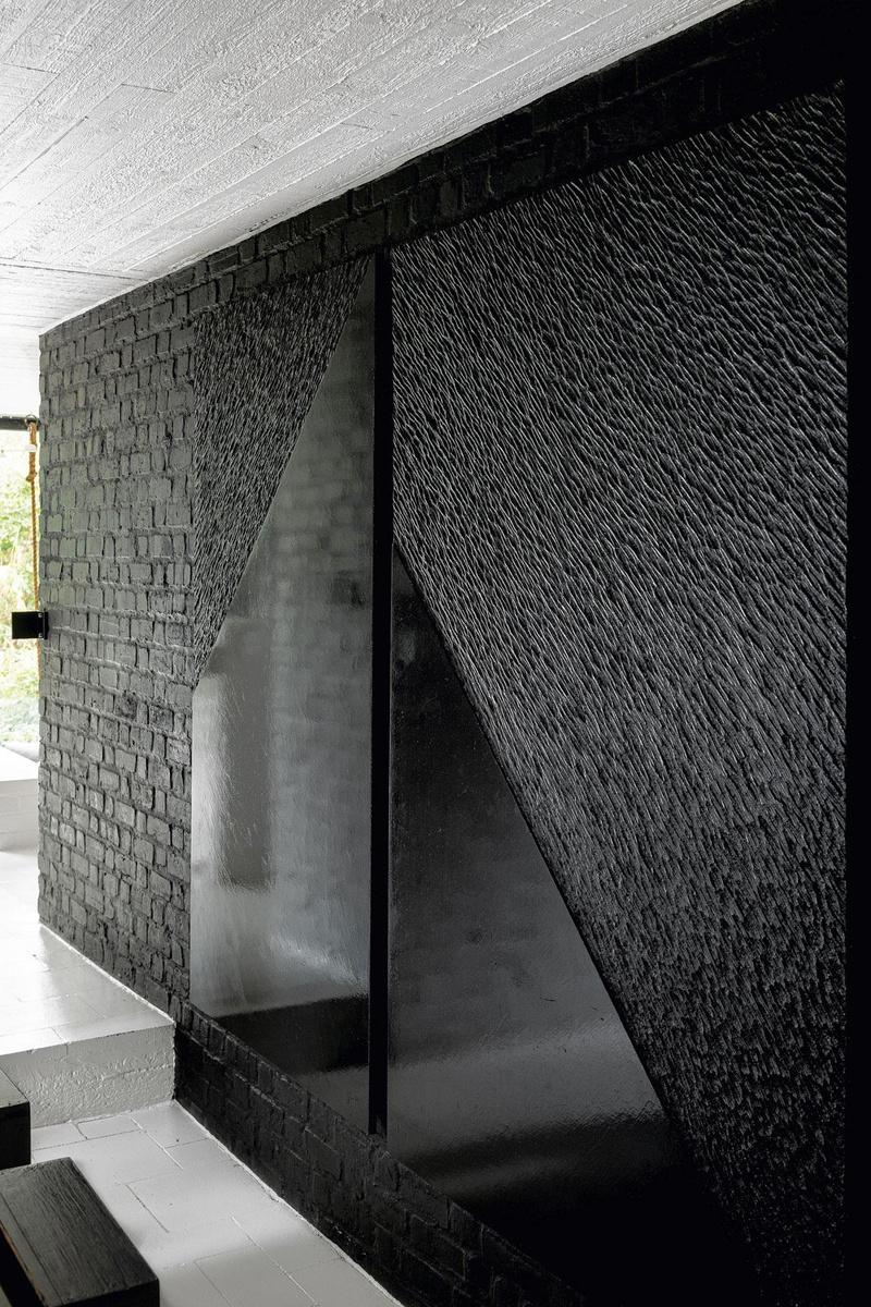 Aux murs de l'habitation, pendent des sculptures abstraites sur bois, peintes en noir ou en blanc.