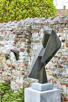 Les oeuvres tout en modernité tranchent avec le mur en brique qui délimite le jardin.