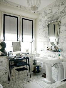 La salle de bains a été refaite mais semble d'origine, avec ses revêtements en marbre et son lavabo rétro.