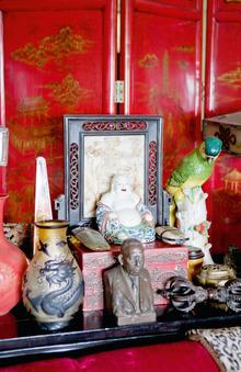 Dans le séjour, trône une collection de curiosités chinoises, à l'instar de ce souriant bouddha assis sur une boîte rouge antique. 