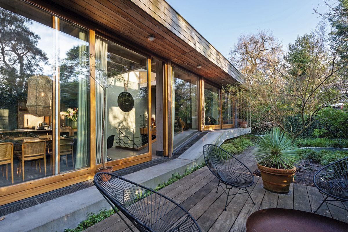 La façade de la maison mixe un bardage en pin thermo-traité et un revêtement en pierre recyclée.