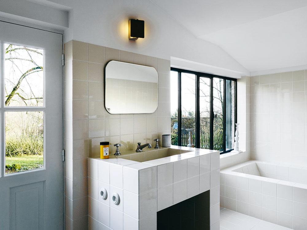 Une salle de bains carrelée et une grande baignoire qui fait face au paysage : 