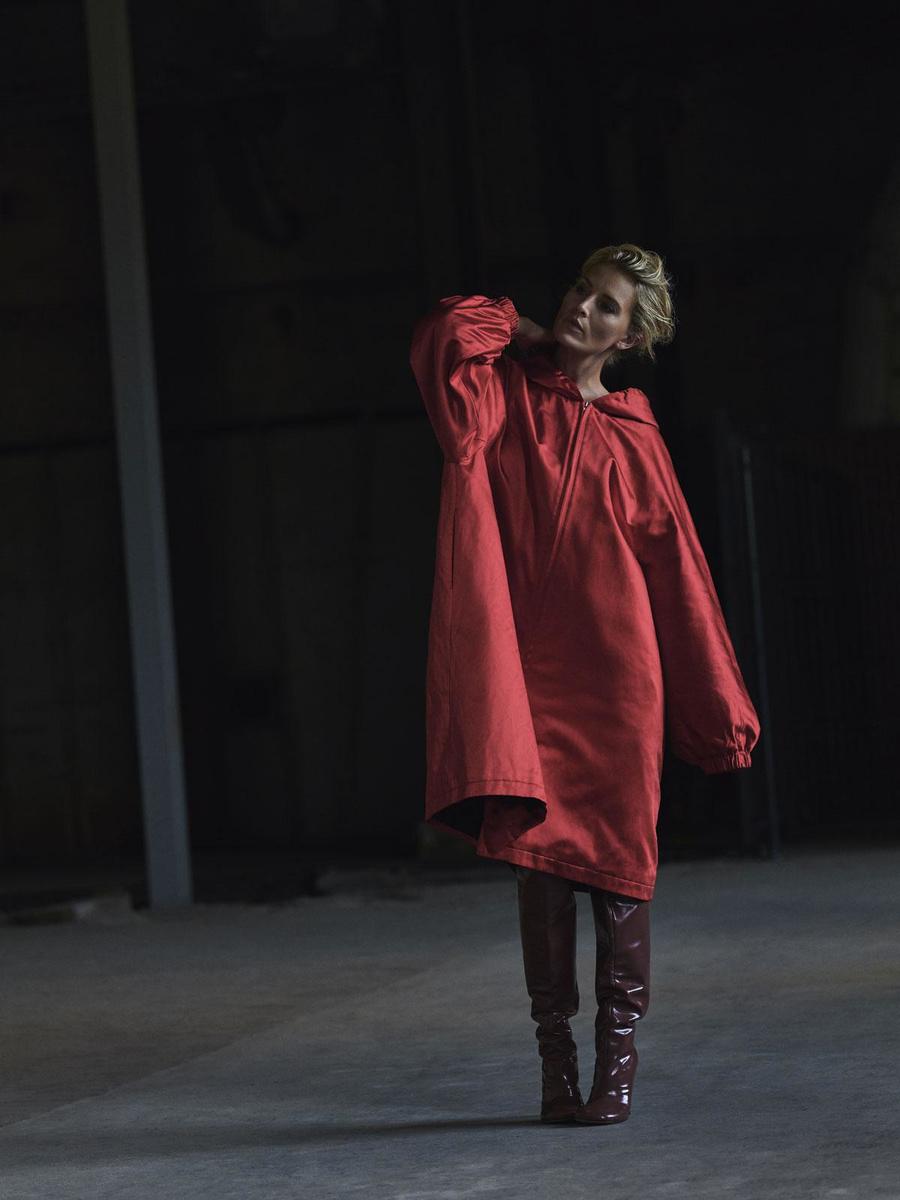 Ingrid: Veste à capuche en satin rouge et bottes en cuir verni, le tout Dries Van Noten.