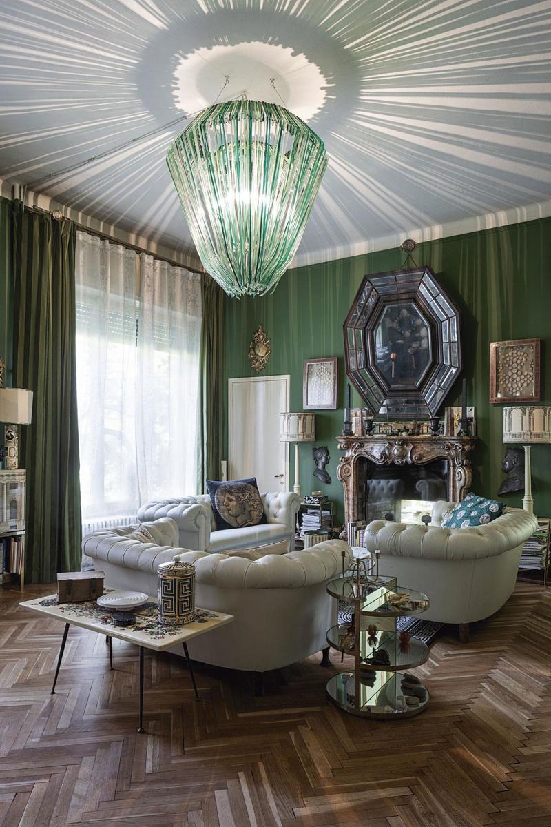 Barnaba a transformé la salle à manger d'antan en un salon vert, avec la collection de miroirs anciens de Piero et deux canapés Chesterfield blancs des années 60.