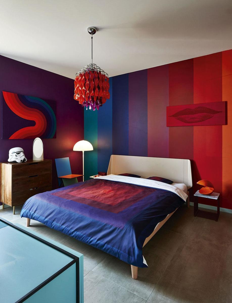 La chambre à coucher est peinte avec huit nuances de couleurs Panton. Même le couvre-lit, la chaise Ikea, dans le coin, et la décoration murale ont été conçus par le Danois.