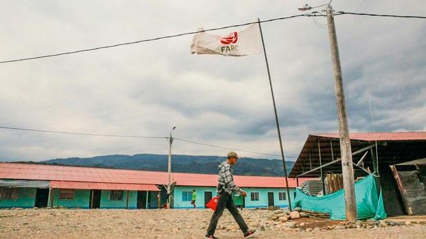 Een ex-FARC-strijder loopt onder de vlag van de ontmantelde guerrillabeweging.