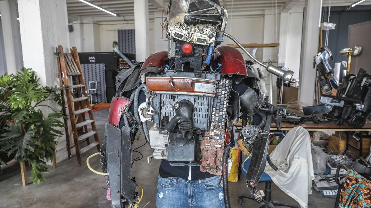 Precy Numbi, travaille ses robots sapiens dans l'atelier de Café Congo installé dans une ancienne usine textile d'Anderlecht, essentiellement avec des matériaux de récupération.