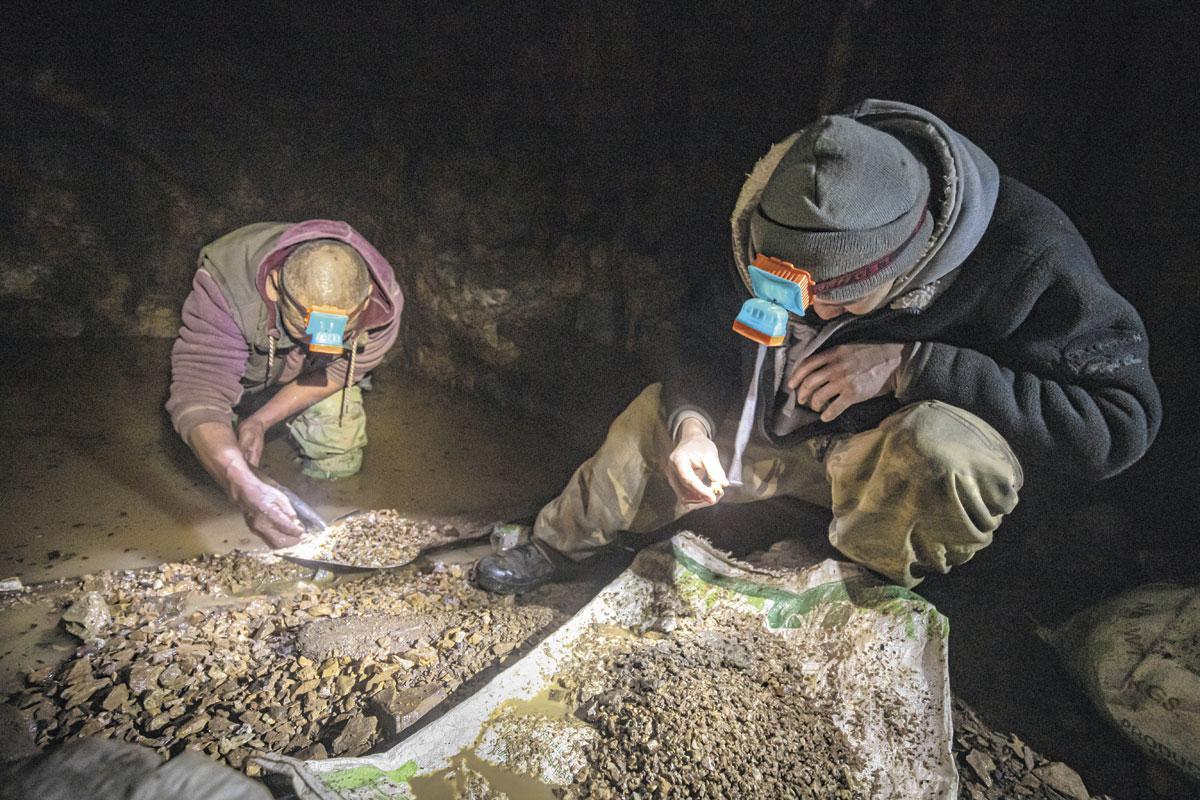 Ces orpailleurs cherchent des restes d'or dans une ancienne réserve d'eau ayant servi au lavage du minerai.