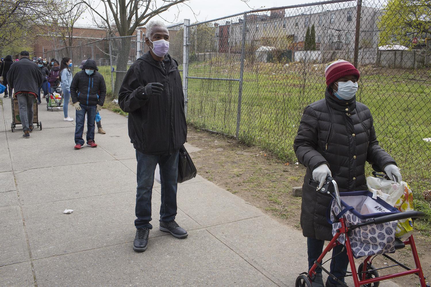 Des résidents du quartier font la file pour la distribution de vivres de la Campagne Bed Stuy contre la faim, le 23 avril 2020 à Brooklyn, New York. En raison de l'augmentation du chômage, les files d'attente se sont allongées.