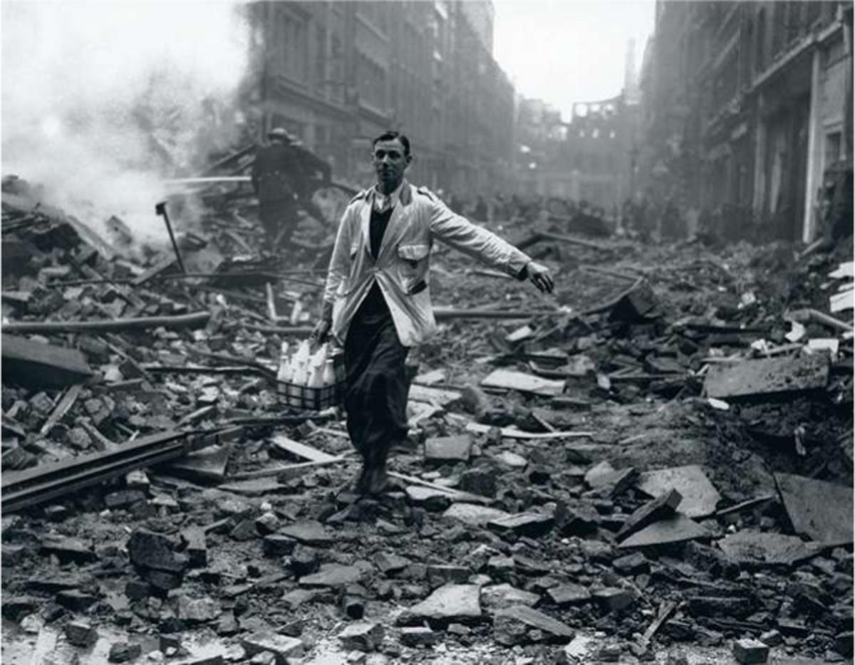 10 septembre 1940. Un laitier transporte ses bouteilles dans une rue dévastée de Holborn, dans le West End londonien. Derrière lui, les pompiers s'affairent.