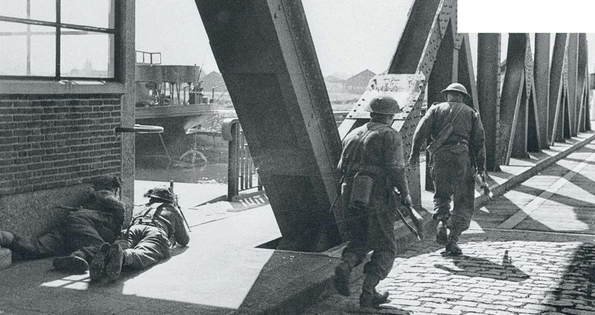 Des soldats anglais s'abritent des tirs allemands sur un pont, à Anvers.