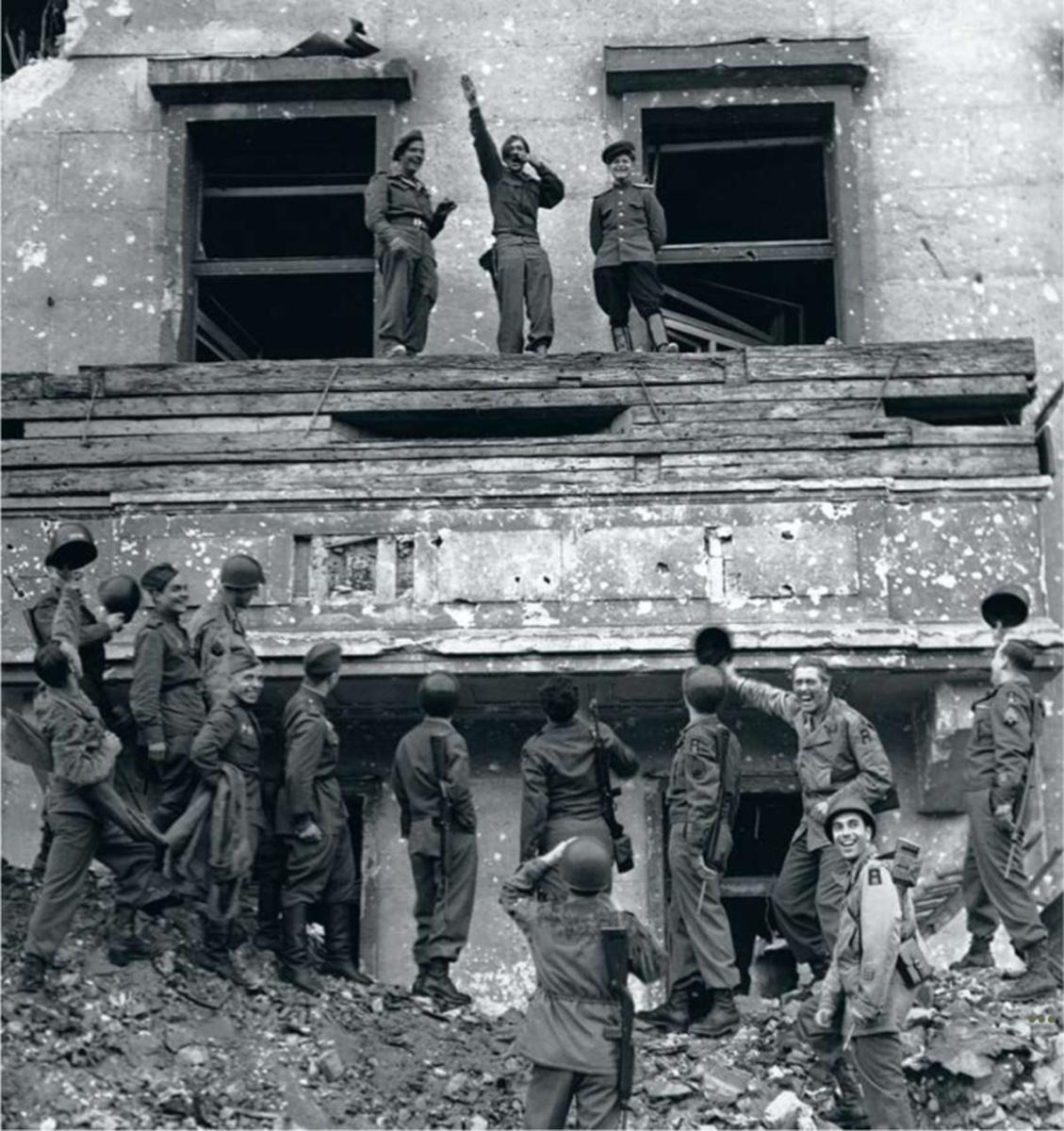 A Berlin, au balcon de la Chancellerie détruite, les soldats américains, anglais et russes, unis, se moquent d'Adolf Hitler.