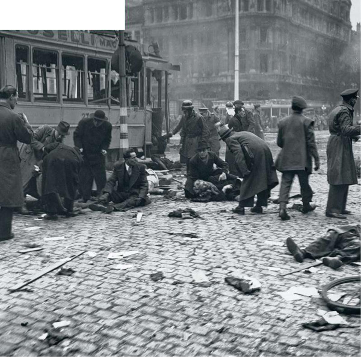Des passants viennent en aide à des civils blessés par une bombe V2 à Anvers, en 1944, qui fera une centaine de morts.