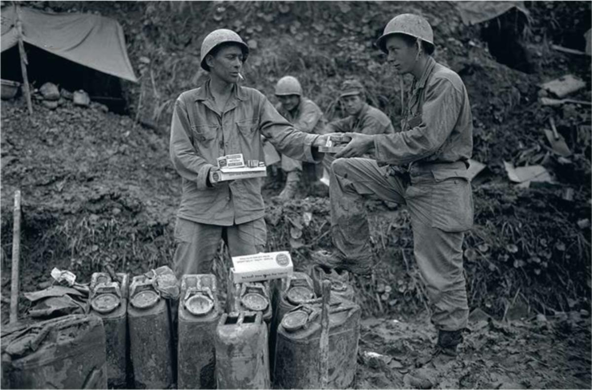 Echange de cigarettes et de friandises entre deux soldats américains sur la ligne de front.