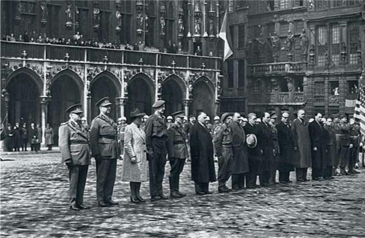 Des résistants belges sur la Grand-Place de Bruxelles attendent au garde-à-vous d'être décorés.