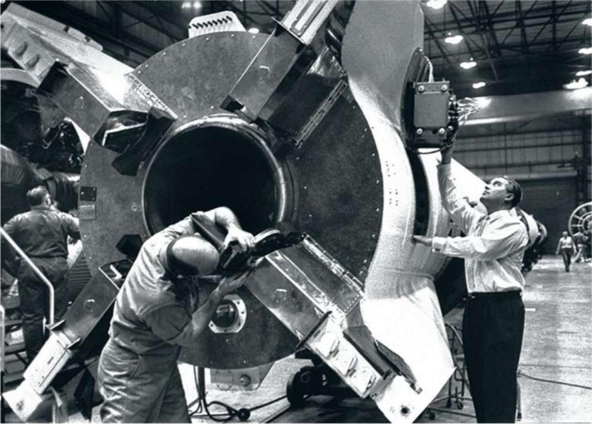 Werner Von Braun (à g.) examine un missile Redstone, l'ancêtre du lanceur Mercury, dans l'immense laboratoire du siège de l'usine Redstone.