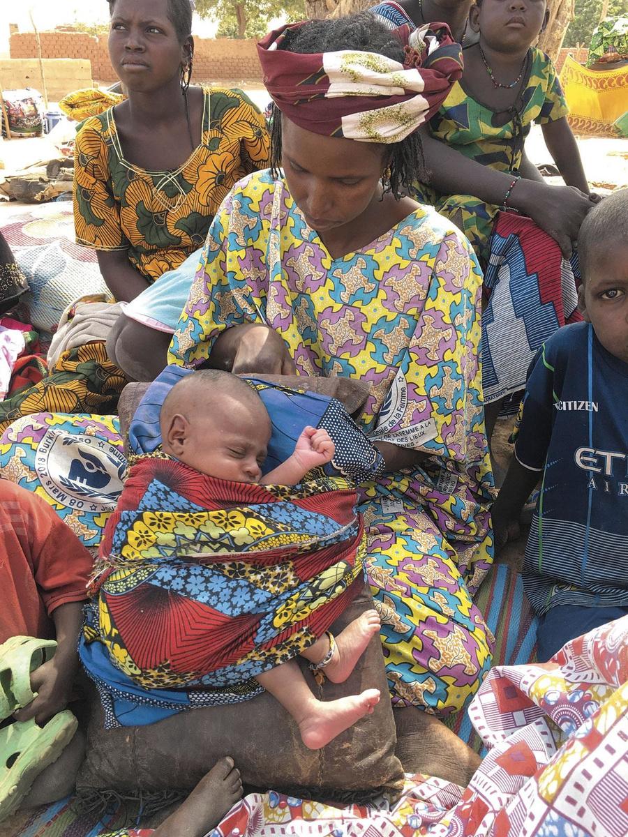 A la frontière de la zone rebelle, une Malienne en fuite présente son bébé à l'écrivaine, sans un mot.
