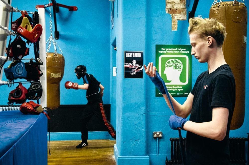 Joel, 15 ans, se bande la main avant sa séance de boxe, à l'est  de Belfast. Ouverte à tous, elle n'est toutefois fréquentée  que par des jeunes protestants.