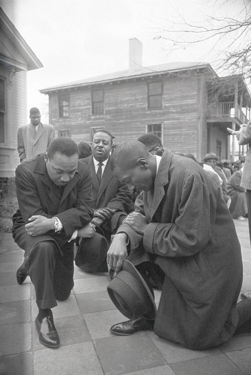 Le genou à terre opposé aux violences policières actuelle fait référence au geste du pasteur Martin Luther King, lors d'une manifestation pour les droits civiques en 1965 à Selma à Montgomery en Alabama.