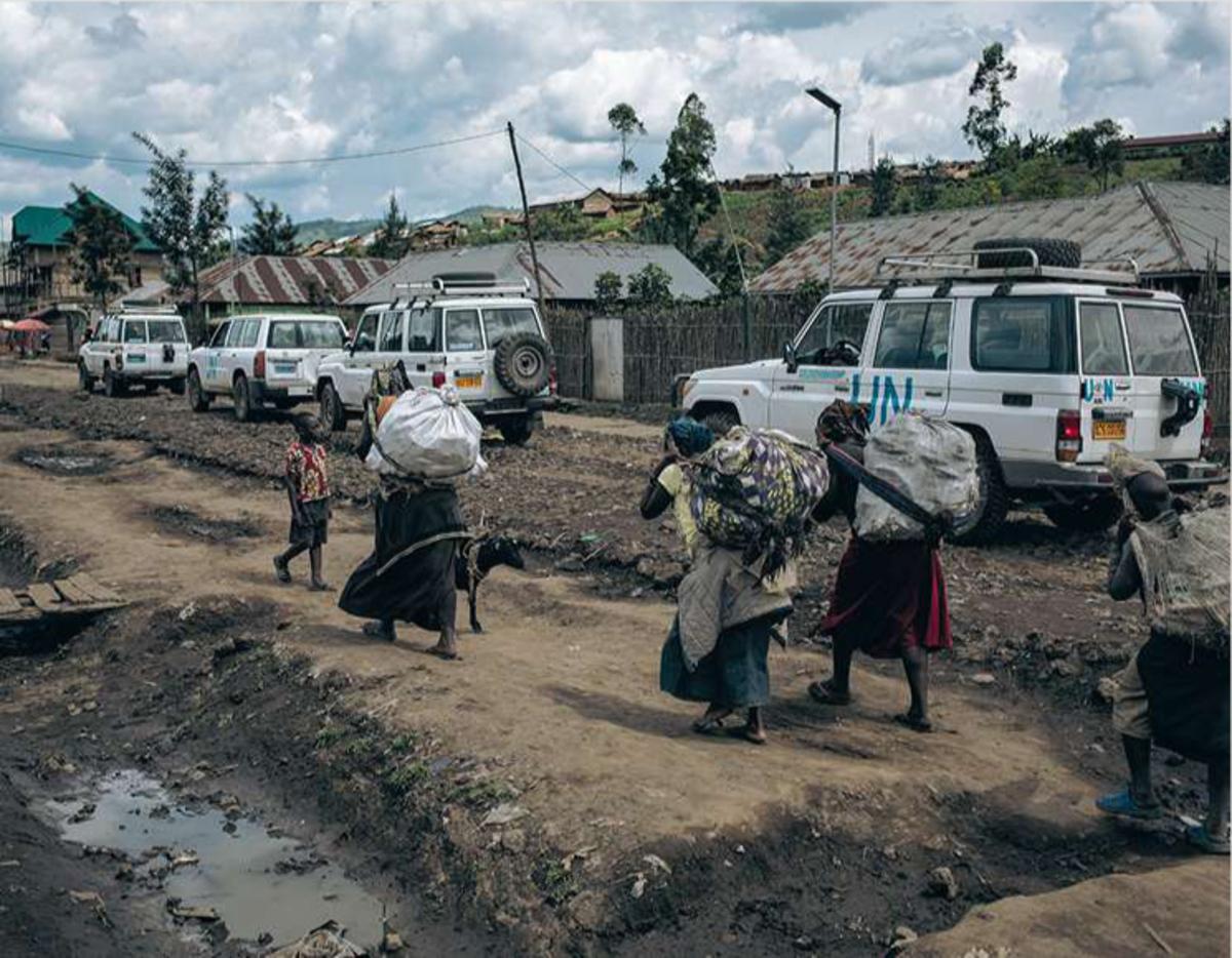 Avril 2019. Des femmes, de retour vers Mweso (Nord-Kivu) avec leurs récoltes, passent devant un convoi du programme de stabilisation de la Monusco, la mission de maintien de la paix des Nations unies en RDC.