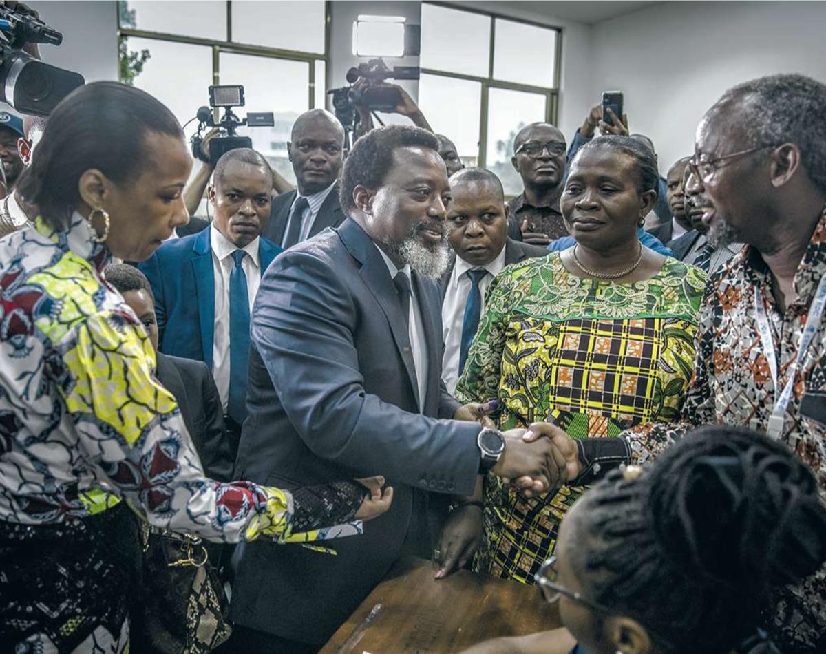 Le président sortant Joseph Kabila salue des observateurs électoraux après avoir voté au bureau situé à l'Institut de la Gombe, lors des élections générales du 30 décembre 2018.