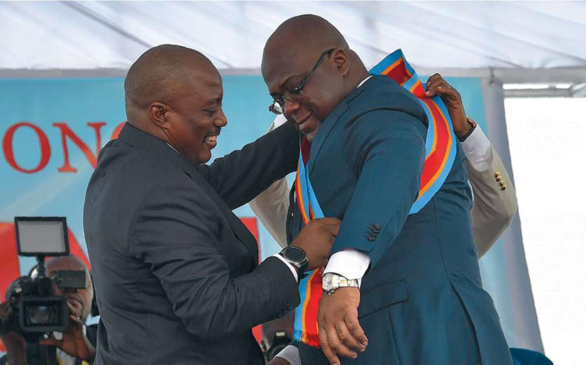 Kabila et Tshisekedi: le plus jeune cède l'écharpe présidentielle au plus âgé.