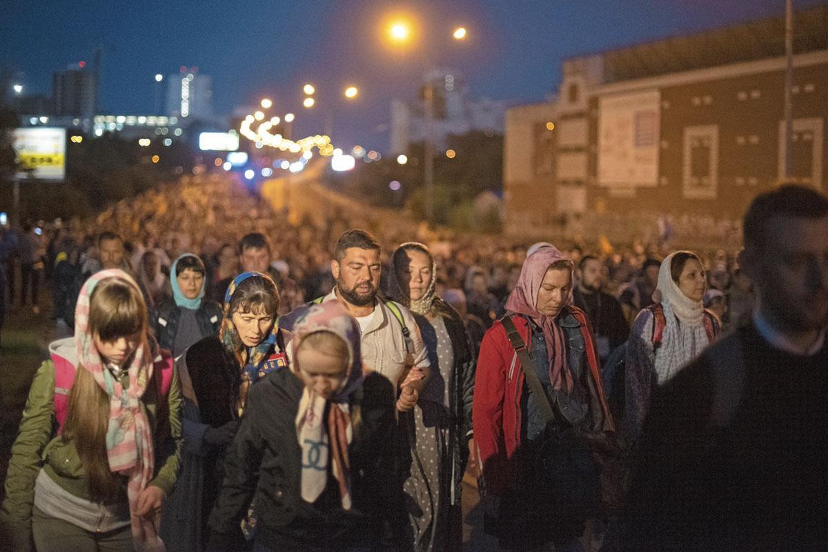 Au milieu de la nuit, des milliers de personnes marchent groupées. 